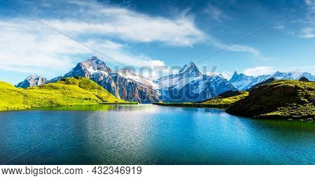 Panorama of Bachalpsee lake in Swiss Alps mountains. Snowy peaks of Wetterhorn, Mittelhorn and Rosenhorn on background. Grindelwald valley, Switzerland. Landscape photography