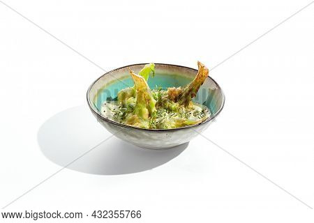 Fried tempura broccoli with peanut sauce in bowl. Vegeterian hot dish - florets cabbages roasted  in klar on white background. Veggie menu for asian restaurant. Hot vegan appetizers plant based