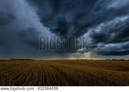 Dark Storm Clouds In An Agricultural Field In Autumn. An Impending Storm, Hurricane Or Thunderstorm.