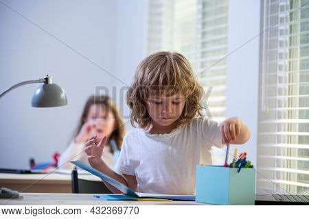First Grader. Back To School. Happy Cute Child Is Sitting At A Desk Indoors. Cild Is Learning In Cla