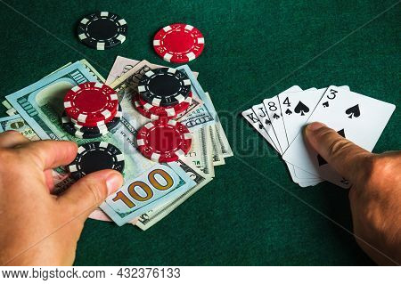 Player Points With His Finger At A Winning Flush Combination In Poker Game On A Table With Chips And
