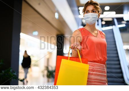 Young woman in a mall wearing a protective mask against covid 19 coronavirus pandemic