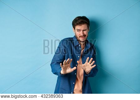 Man Cringe And Stay Away From Something Nasty, Looking Aside And Stretch Out Hands To Reject Bad Dea