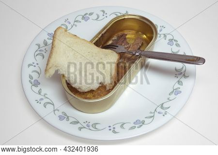 Canned Fish, Sardines In Oil, And Small Metal Fork With Three Prongs. Open Tin Can Without Lid And A