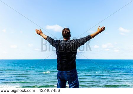 Caucasian Man Spreading Arms And Watching The Ocean. Happy Man With Outstretched Arms.man With His A