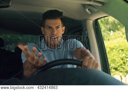 Stressed Angry Man In Driver's Seat Of Modern Car, View Through Windshield