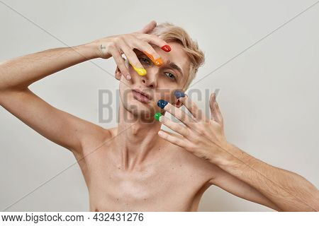 Portrait Of Young Transgender With Fingers In Colorful Rainbow Lgbtqi Paint Looking At Camera While 