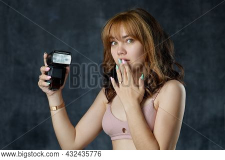 A Beautiful Girl Holds A Flashbulb In Her Hands. Photo Accessories. Teaching Photography How To Use 