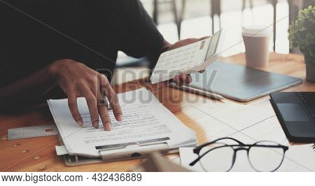 Man Calculating Financial Chart For Investment To Buying Property With House Model. Money Saving Con