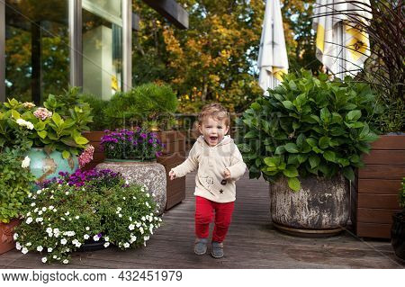 Little Smiling Boy Runs On A Terassa Of Cafe.  Lovely Kid Smiles And Has Joy. Outdoor Activities For