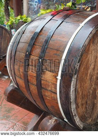 A Traditional Old Wooden Barrel With Curved Walls And Metal Hoops. Dishes For The Ripening Of Alcoho