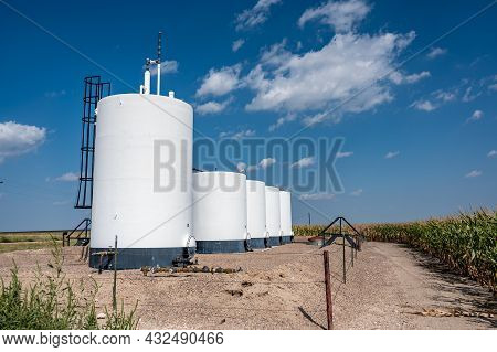 Crude Oil Storage Tanks With Secondary Containment And Fencing In A Rural Corn Field