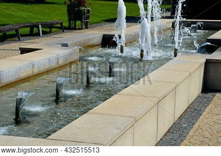 Swimming Pool With Fountains In The Shape Of An Opposite Cross On The Promenade In The Park On The S