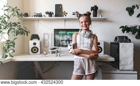 Girl Holding White Wireless Gamepad Against White Computer Dream Desk.