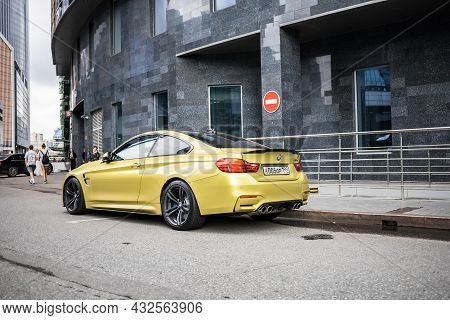 Bmw M4 Competition Package Parked On The Street In Moscow. Yellow Supercar In Front Of Office Buildi