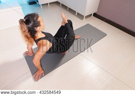 Athletic Caucasian Slim Woman Doing Myofascial Self-massage Of The Thigh And Gluteus Muscles In A Ma