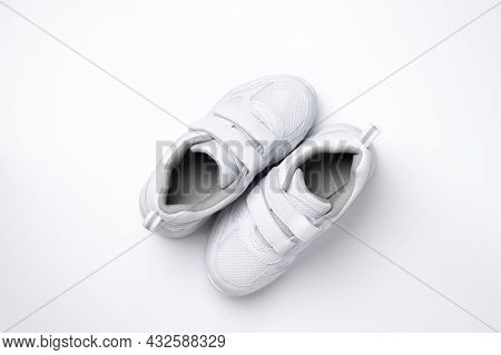Top View Two White Teen Sneakers With Velcro Located Diagonally Isolated On A White Background