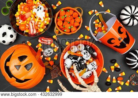Halloween Trick Or Treat Scene With Jack O Lantern Pails And A Variety Of Candy. Top View On A Black