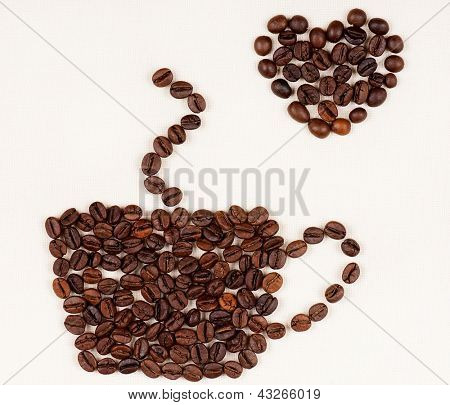 ถ้วยที่ทำจากเมล็ดกาแฟด้วยใจบนผืนผ้าใบแสง