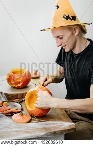Man Curving Jac O Lanten Helloween Pumpkin At Home. Getting Ready For The Holiday,