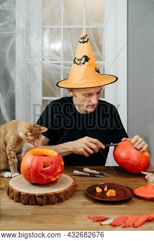 Man Curving Jac O Lanten Helloween Pumpkin At Home. Getting Ready For The Holiday,