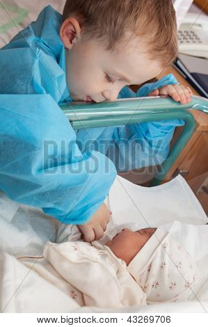 Boy Feeding A Newborn Sister