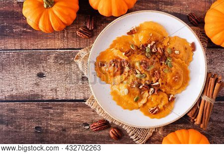 Pumpkin Filled Ravioli Pasta With Nuts And Pumpkin Seeds. Top View On A Rustic Wood Background. Copy