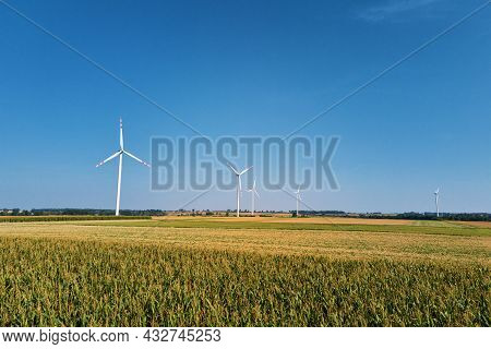 Windmill Among Agricultural Fields. Wind Turbine Generator At Summer Day. Wind Energy Concept. Suist