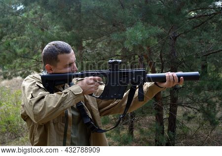 Man with KRISS Vector 9*21 caliber submachine gun in the forest. Unformal shooting range near Kiev. September 6,2021. Kiev Region, Ukraine