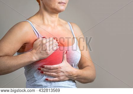 Breast Cancer In Women. The Woman Is Holding Her Chest, The Area Of Inflammation Is Marked In Red.