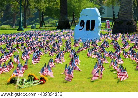 September 11, 2021 In Whittier, Ca:  Flowers Placed Besides Rows Of American Flags On A Lush Manicur