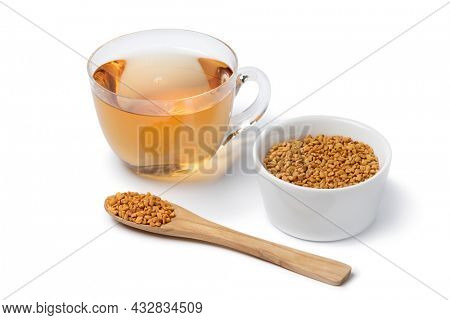 Glass cup with Fenugreek tea and a spoon and bowl with Fenugreek  seeds isolated on white background