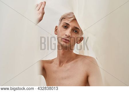 Portrait Of Gentle Young Transgender With Makeup Looking At Camera While Posing Isolated Over Light 