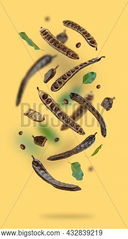 Creative Composition. Floating Organic Carob Pods, Seeds, Leafs On A Beige Food Background. Natural 