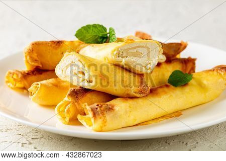 Blintz, Rolled Filled With Sweetened Cottage Cheese Pancakes Or Crepes On A White Plate On A Wooden 