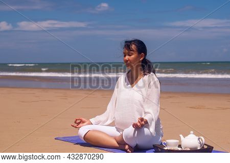People And Leisure Concept- Back View Of Woman Meditating And Drinking Tea On The Tropical Beach Wit