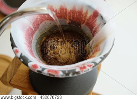 Coffee Brewing Process. Pouring Water From Gooseneck Kettle. Freshly Roasted Coffee Blooming. Potter