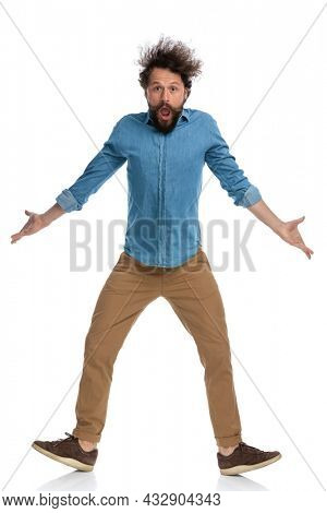 attractive casual man feeling shocked and having no clue what's happening on white background