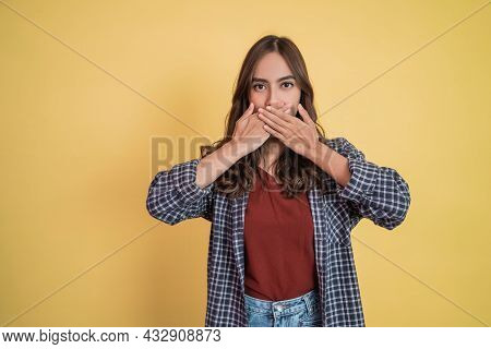 An Asian Woman With Long Hair Covering Her Mouth With Both Hands With Copyspace