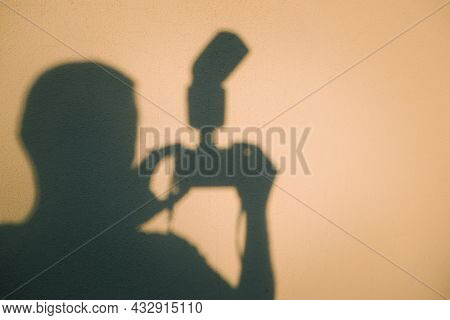 Photographer`s Shadow. Shadow From A Male Photographer On A Gray Wall. Shot Of A Self Shadow Of A Ph