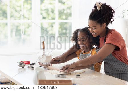 Cheerful Black Mother Helping Daughter Rolling Pasrty Dough