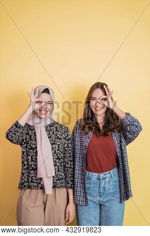 Two Smiling Women With Ok Approval Hand Gesture Affixed To One Eye With Copyspace Above