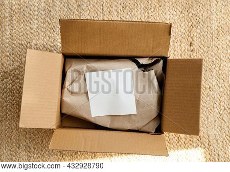 Overhead View Of New Parcel Delivery Unboxing On Floor With White Paper On The Protected Paper