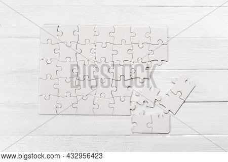 Small white puzzle sample on wooden table