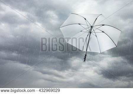 White Umbrella Blowing Away In Dark Cloudy Sky On Windy And Rainy Storm Day, Depth Of Field. Scene O