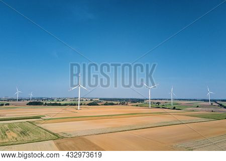 Windmill Among Agricultural Fields. Wind Turbine Generator At Summer Day. Wind Energy Concept. Suist