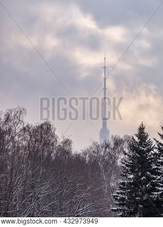 Ostankino Television Tower In The Fog Through Winter Tree Branches. Ostankino Tv Tower In Moscow, Ru