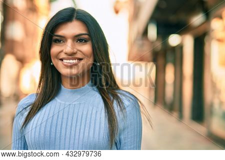 Beautiful hispanic woman smiling confient at the city