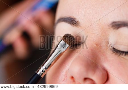 Face Painting. Makeup Artist Applying Make Up To Adult Model Eyes. Cosmetic Beauty Procedures, Makeu
