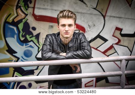 Handsome Blond Haired Young On Railing Looking In Camera